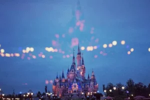 Château rose illuminé à la tombée de la nuit.