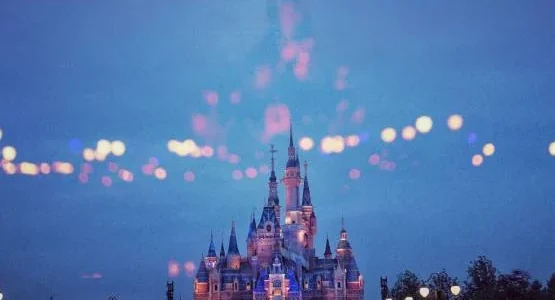 Château rose illuminé à la tombée de la nuit.