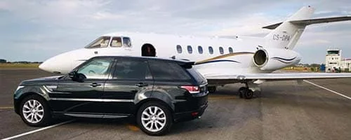 SUV noir stationné devant un avion d’affaires sur un tarmac.
