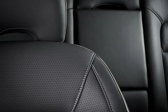 Gros plan sur des sièges en cuir noir dans une voiture.