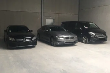 Véhicules VTC Lille Hauts-de-France Deux berlines et un van stationnés dans un garage.